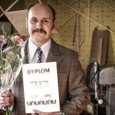 Adam Woronowicz z bukietem i dyplomem, jakby po premierze jednego z jego filmów.