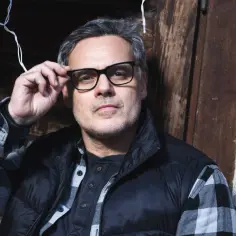 Jan Wieczorkowski w okularach, w kratę, przygotowuje się do kolejnych filmów, seriali i programów.
