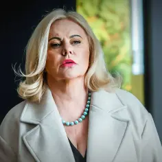 Joanna Kurowska w eleganckim płaszczu i perłach, gotowa do roli w kolejnych filmach.