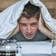 Następnego dnia rano, mężczyzna z przerażeniem w oczach chowa się pod kołdrą, obok niego stoi dzbanek kawy i szklanka wody.