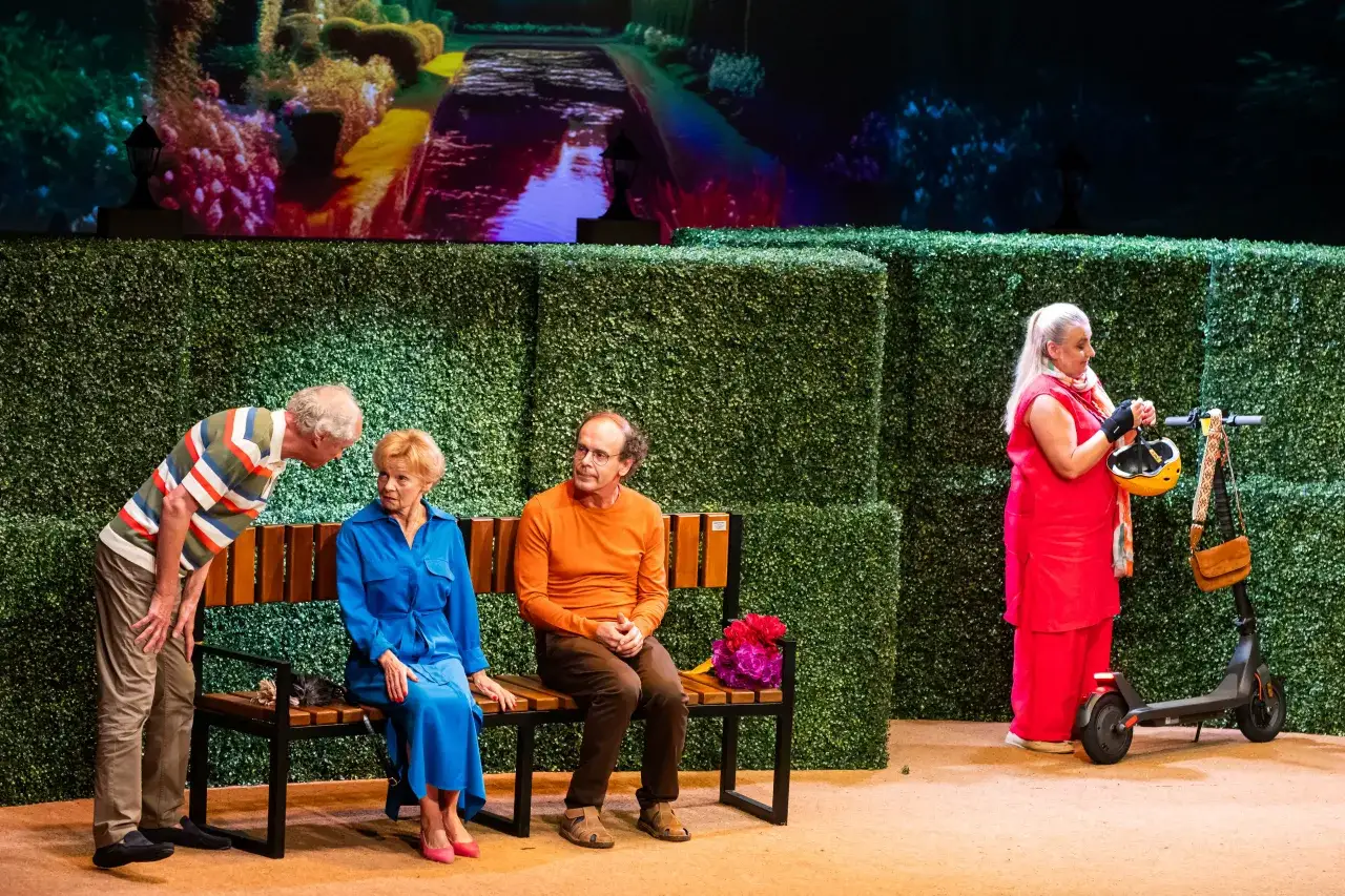 Scena teatralna z ludźmi i skuterem. Zastanawiasz się, na co warto iść do teatru w Warszawie?