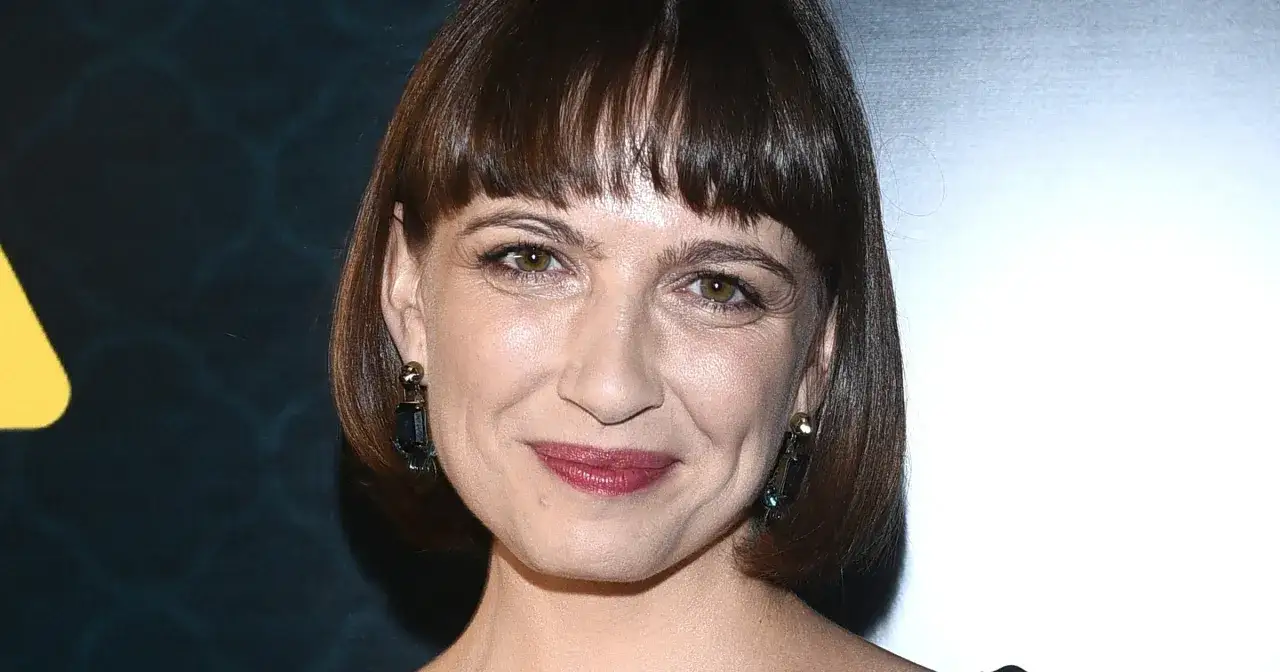 Uśmiechnięta Anna Cieślak, znana z wielu filmów, seriali i programów, w eleganckich kolczykach.