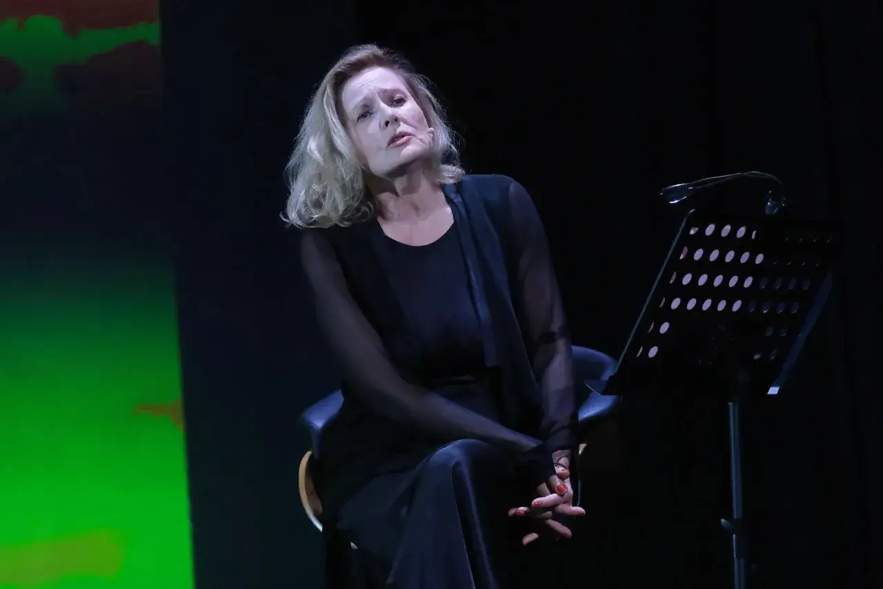 Grażyna Szapołowska na scenie, w czerni, zamyślona. W tle zielone światła, przypominające scenografię z jej filmów.